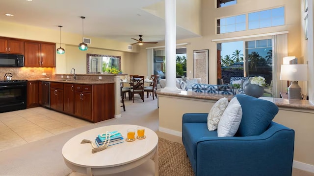 kitchen with sink, tasteful backsplash, black appliances, decorative light fixtures, and kitchen peninsula