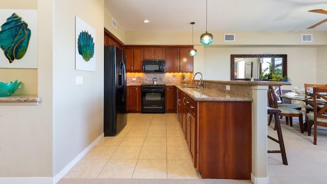 kitchen featuring sink, black appliances, kitchen peninsula, and a kitchen bar