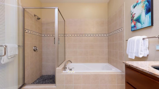 bathroom with vanity and shower with separate bathtub