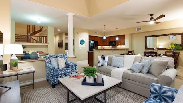 living room with decorative columns and ceiling fan