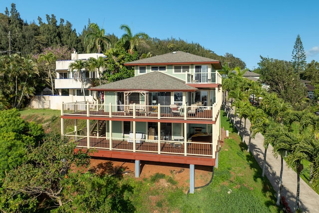 back of property featuring a lawn and a balcony