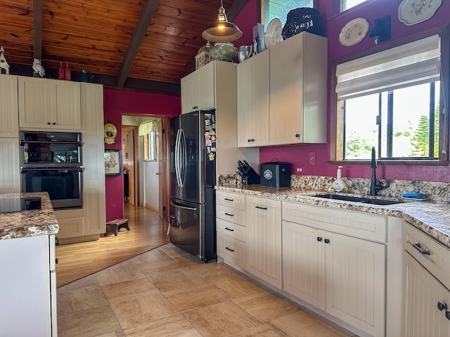 kitchen featuring wood ceiling, hanging light fixtures, light stone countertops, black appliances, and a sink