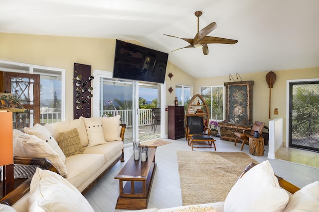 living room with vaulted ceiling, ceiling fan, and light wood-type flooring