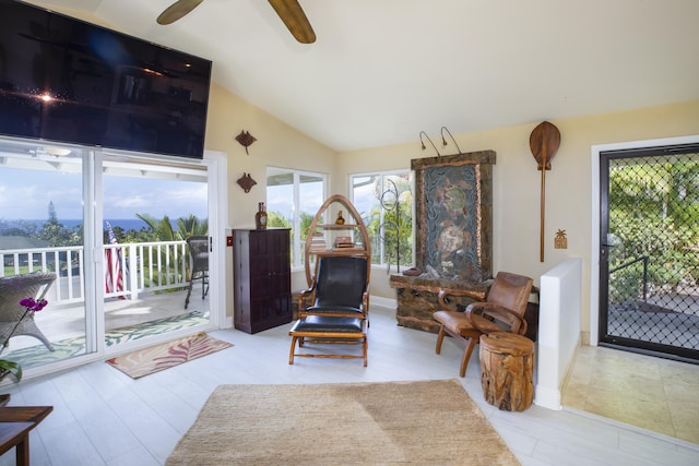 living area with ceiling fan, lofted ceiling, and light hardwood / wood-style floors