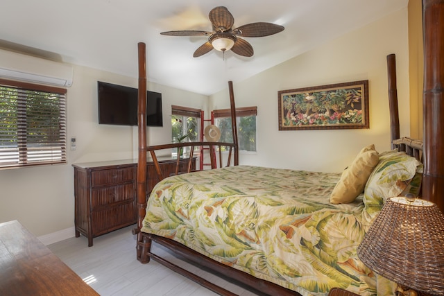 bedroom with vaulted ceiling, an AC wall unit, ceiling fan, and light hardwood / wood-style flooring