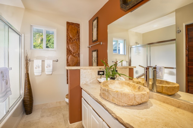 full bathroom with enclosed tub / shower combo, a healthy amount of sunlight, toilet, and vanity