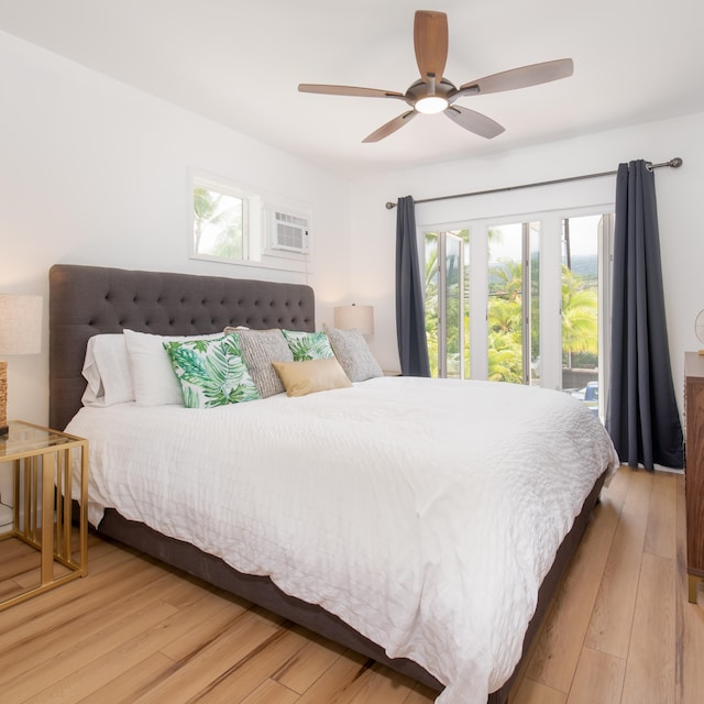 bedroom featuring multiple windows, light hardwood / wood-style floors, an AC wall unit, and ceiling fan