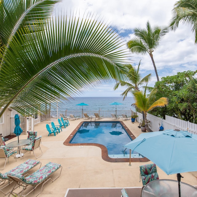 view of pool featuring a patio and a water view