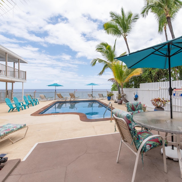 view of pool featuring a water view and a patio area