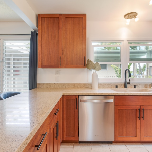 kitchen with dishwasher, light stone countertops, sink, and light tile patterned flooring