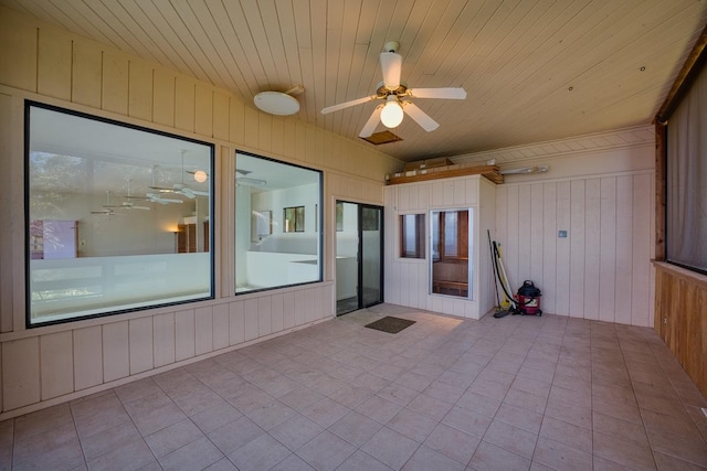 unfurnished sunroom with ceiling fan and wooden ceiling