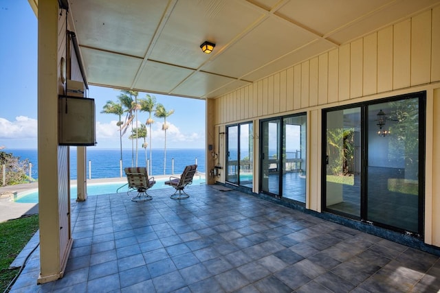 view of patio / terrace with an outdoor pool and a water view