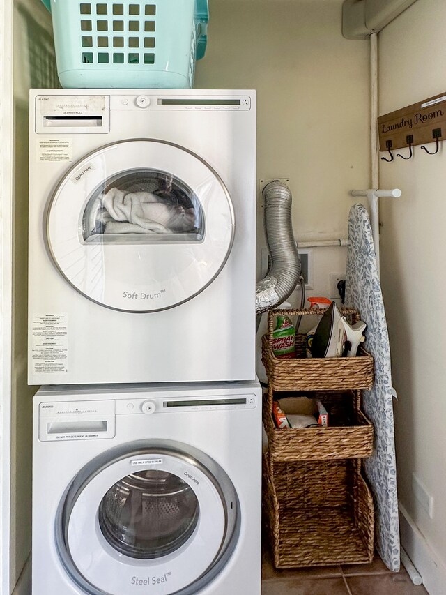 laundry area featuring laundry area, stacked washing maching and dryer, and tile patterned floors