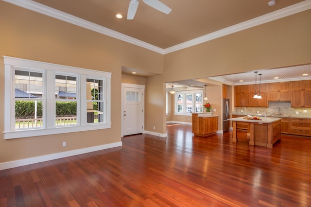 unfurnished living room featuring crown molding, ceiling fan, and dark hardwood / wood-style floors