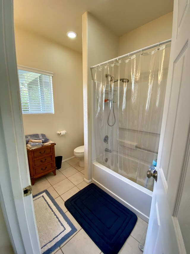 bathroom featuring shower / bathtub combination with curtain, tile patterned flooring, and toilet