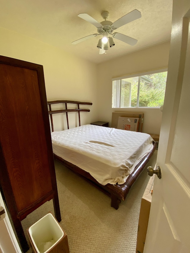 bedroom featuring ceiling fan and carpet