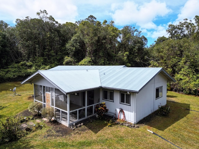 back of property with a yard and a sunroom