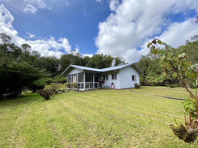 back of house featuring a sunroom and a lawn