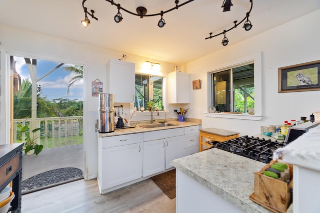 kitchen featuring a healthy amount of sunlight, sink, and white cabinets