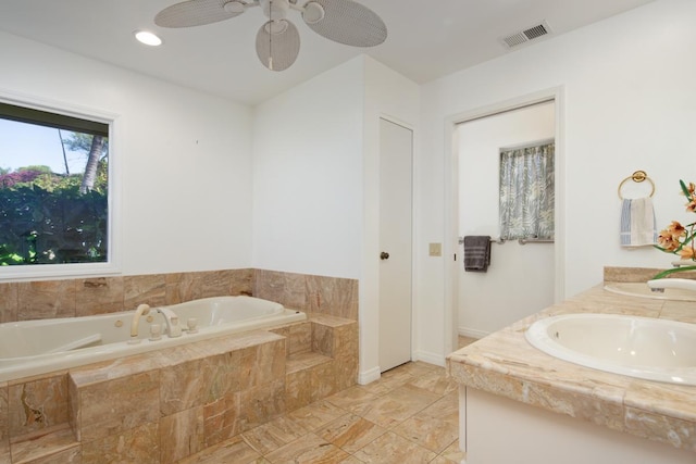 bathroom with vanity and tiled tub