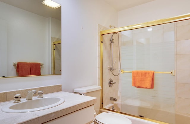 full bathroom featuring enclosed tub / shower combo, vanity, and toilet