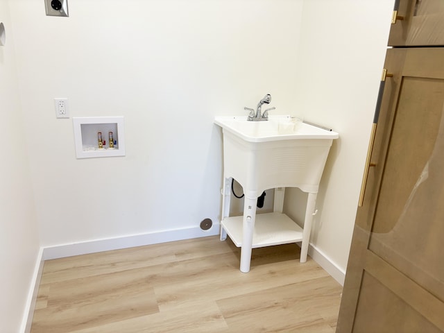 clothes washing area with hookup for a washing machine, hookup for an electric dryer, and light hardwood / wood-style flooring