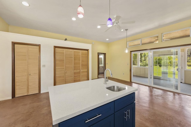 kitchen featuring blue cabinets, a sink, concrete floors, light countertops, and ceiling fan