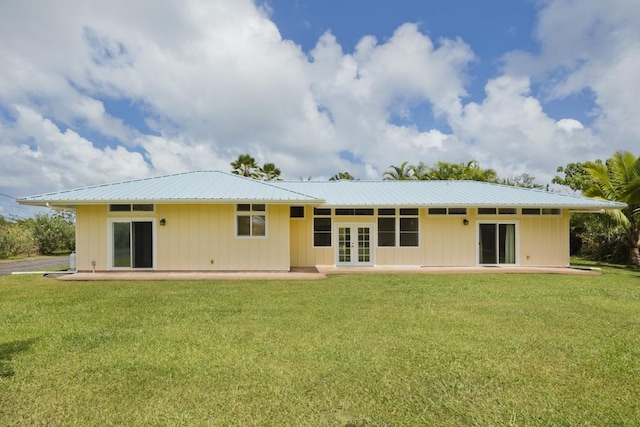 rear view of house featuring french doors, a lawn, metal roof, and a patio area