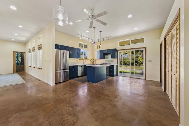 kitchen with a center island, concrete flooring, light countertops, appliances with stainless steel finishes, and blue cabinets