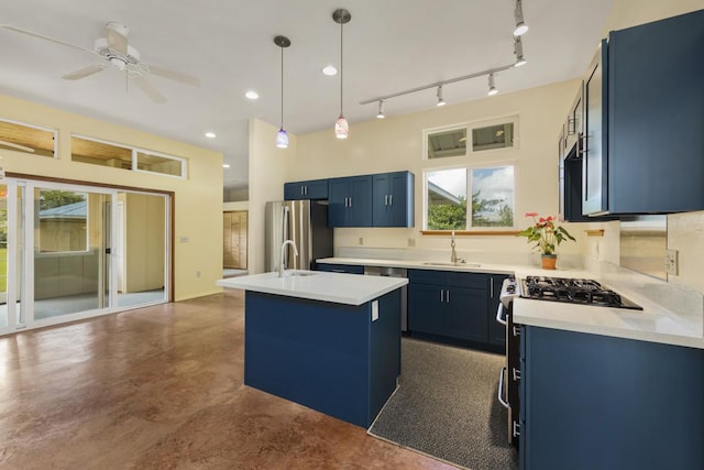 kitchen with freestanding refrigerator, light countertops, blue cabinets, and a sink