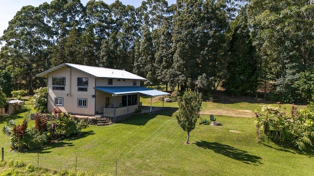 rear view of property featuring a yard