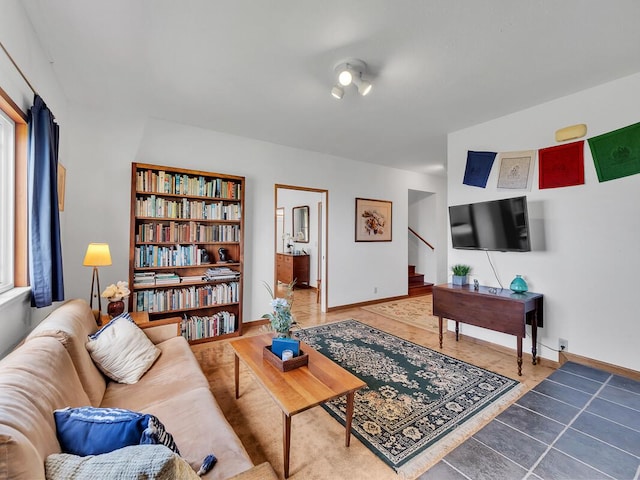 living room featuring tile patterned flooring, stairs, and baseboards