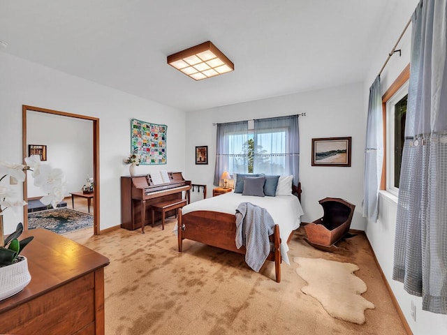 bedroom with light colored carpet and baseboards