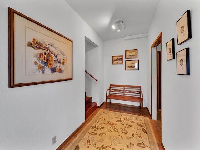 hall featuring light wood-style flooring, stairway, and baseboards