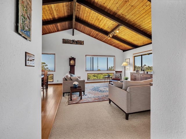 living area featuring beam ceiling, wood-type flooring, a textured wall, wood ceiling, and high vaulted ceiling