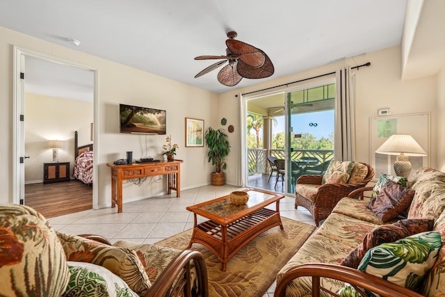 living area with ceiling fan, baseboards, and light tile patterned floors