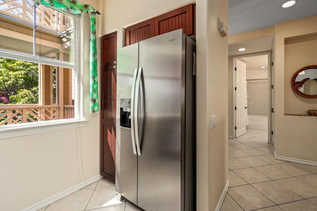 kitchen with baseboards, light tile patterned flooring, and stainless steel fridge with ice dispenser