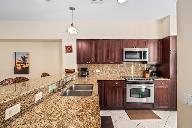 kitchen featuring light tile patterned floors, decorative backsplash, stainless steel appliances, dark brown cabinets, and a sink