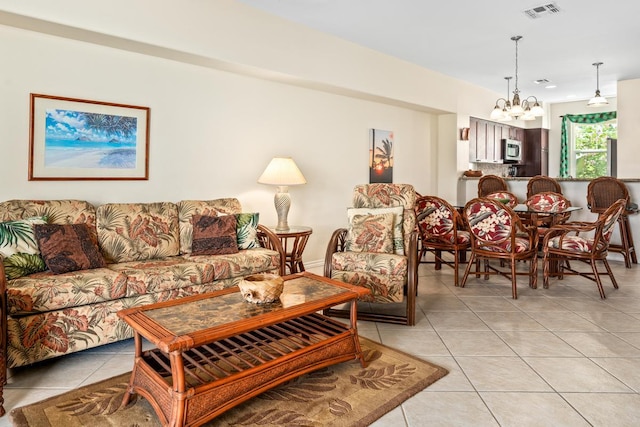 living area featuring visible vents, a notable chandelier, and light tile patterned flooring