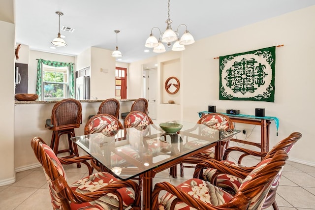 dining room featuring light tile patterned floors, baseboards, visible vents, and a chandelier