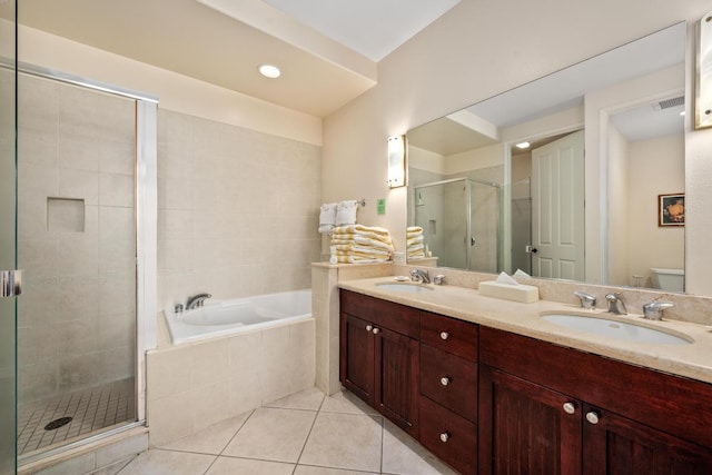 full bathroom featuring a garden tub, a stall shower, tile patterned flooring, and a sink