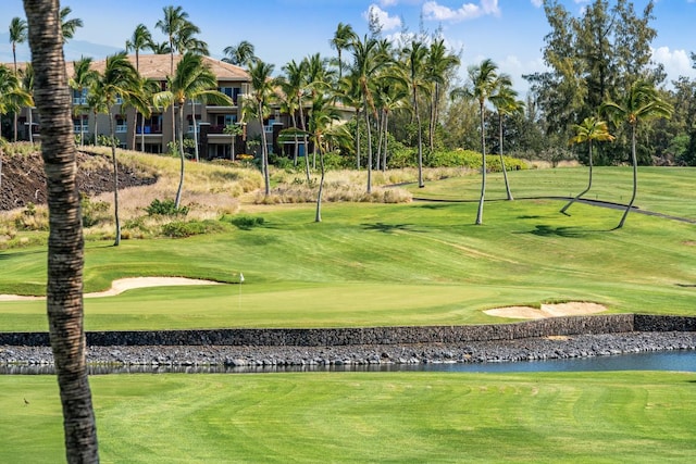 view of home's community featuring golf course view, a water view, and a lawn