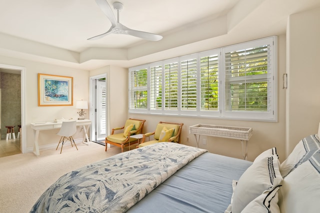 bedroom with ceiling fan, a tray ceiling, and carpet flooring