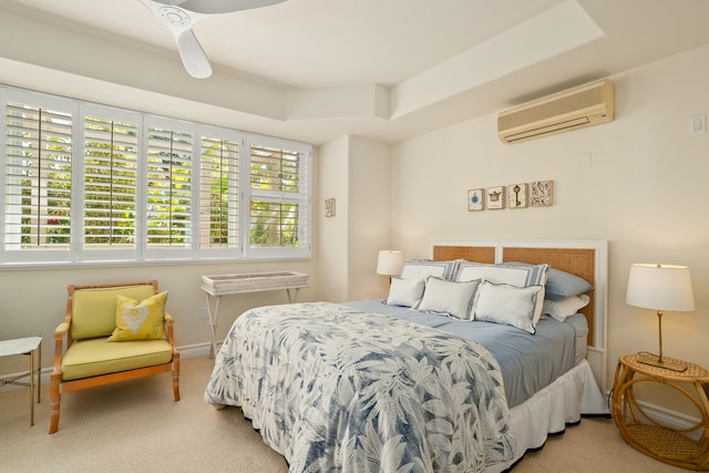 carpeted bedroom with a wall unit AC and a raised ceiling