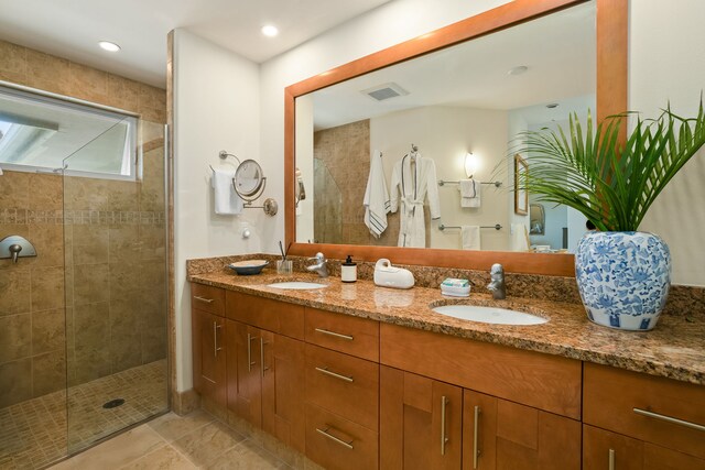 bathroom featuring tiled shower, vanity, and tile patterned floors