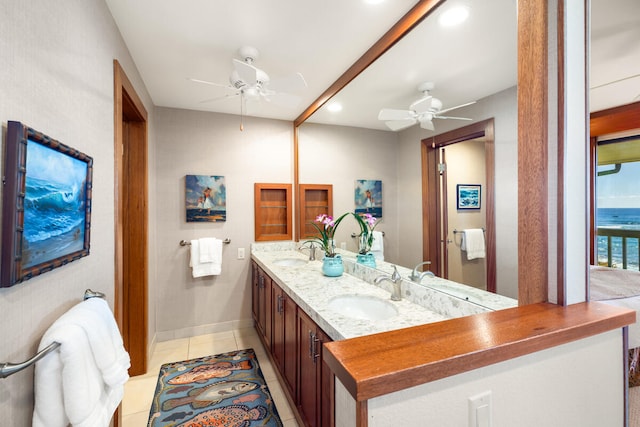 bathroom with tile patterned flooring, vanity, a water view, and ceiling fan