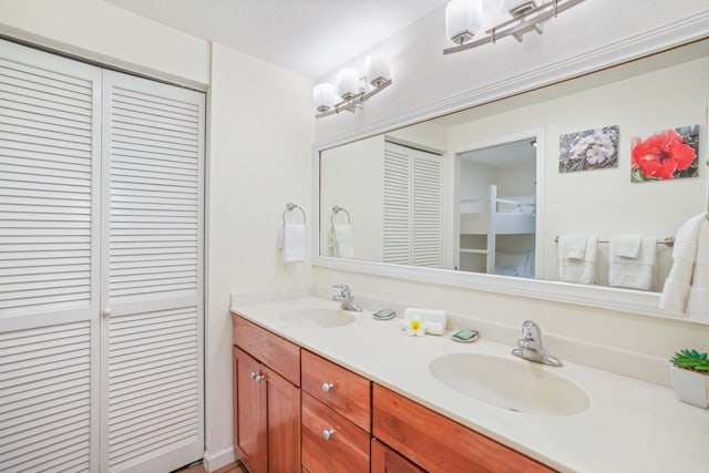 bathroom with a sink, double vanity, and a closet