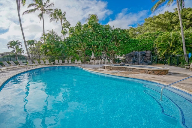 pool featuring a patio area, fence, and an outdoor stone fireplace