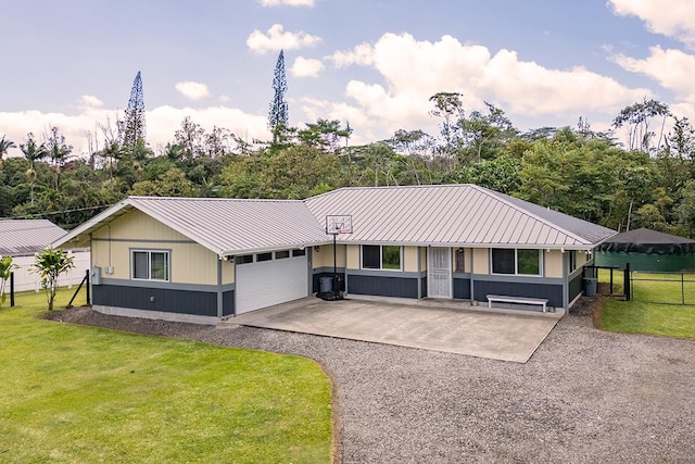 ranch-style home featuring a garage, metal roof, a front lawn, and fence