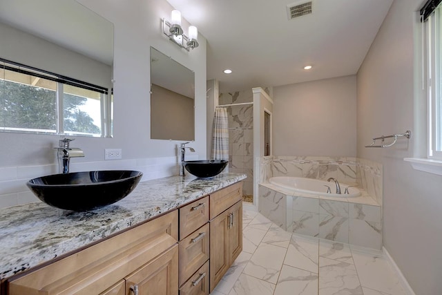 bathroom featuring a relaxing tiled tub, visible vents, a sink, and a tile shower